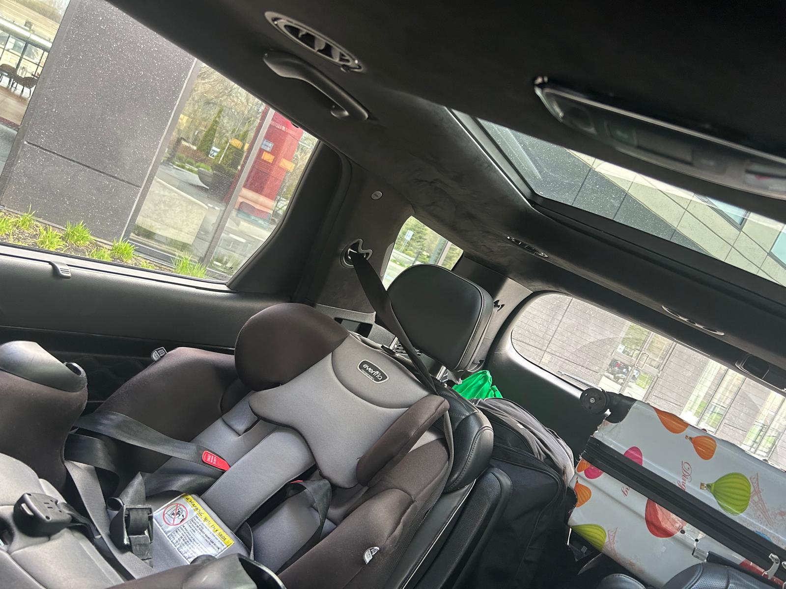 Back seat of the Airport Run Palisade with a child seat installed and luggage loaded